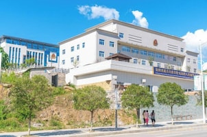 Un edificio de varios pisos con una entrada destacada y señalización.