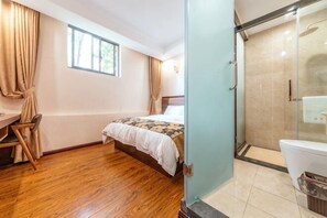A bedroom with a bed, a desk, a chair, a window with curtains, and a bathroom with a toilet and shower. - Bojuejioudian (Daozhen)