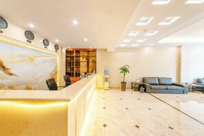 A hotel lobby with a reception desk, seating area, and a plant. - Bojuejioudian (Daozhen)
