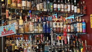Un bar con numerosas botellas de licor y una amplia variedad de copas.