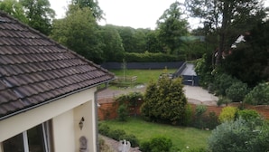 A residential property with a tiled roof, a brick patio, and a well-maintained garden. - Apartment (Castrop-Rauxel)