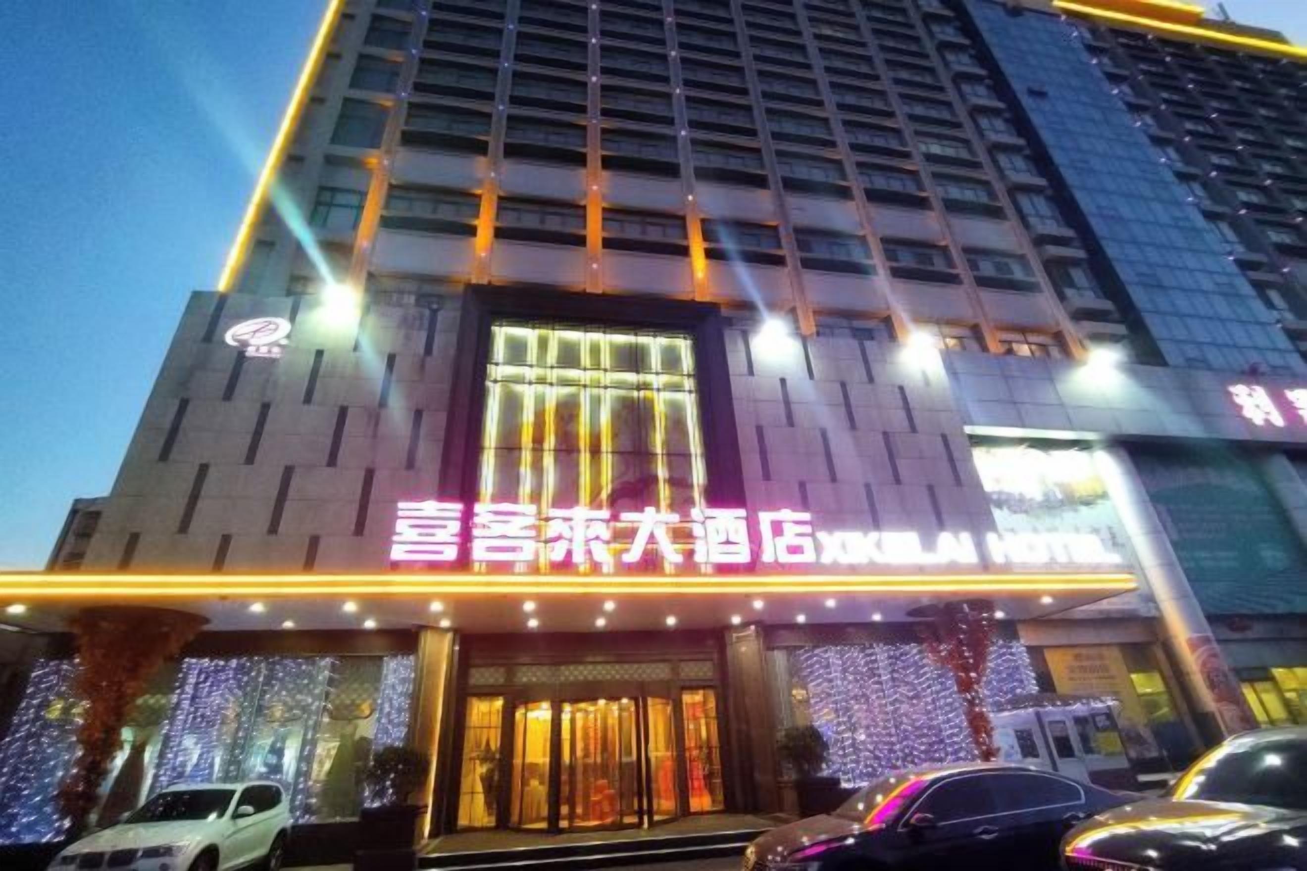 Un hotel con una entrada destacada, señalización iluminada y una fachada moderna.