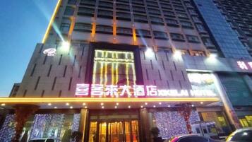 Un hotel con una entrada destacada, señalización iluminada y una fachada moderna.