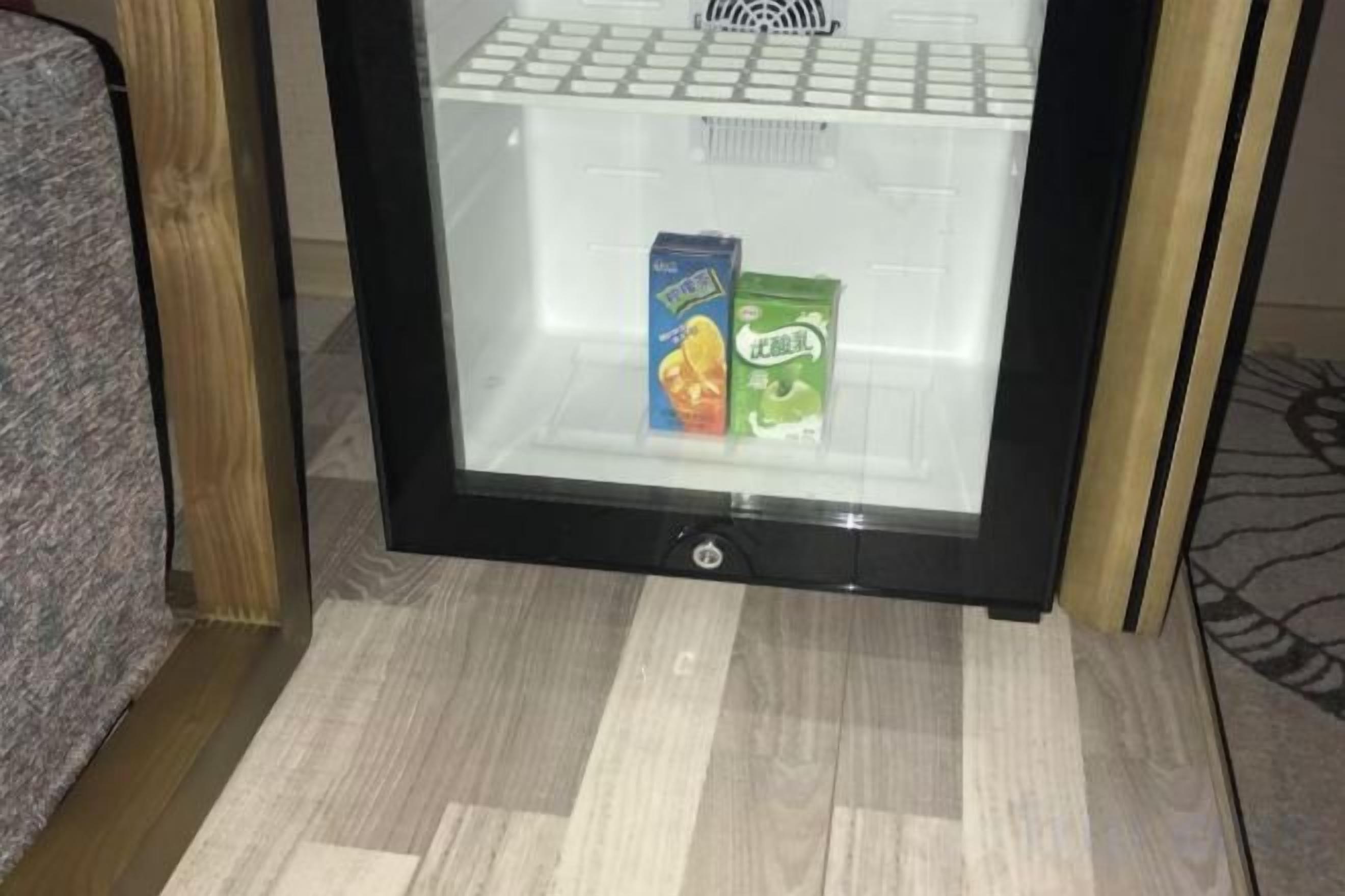 Ein Kühlschrank mit Glastür, der zwei Milchkartons enthält.
