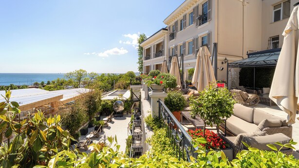 A rooftop terrace with outdoor seating, potted plants, and a view of the sea. - Mula Hotel - Special Class (Istanbul)