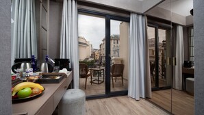 A modern hotel room with a balcony, a dining area with breakfast items, and a view of the cityscape. - Mula Hotel - Special Class (Istanbul)