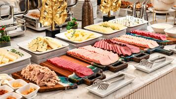 A buffet with various food items and utensils.