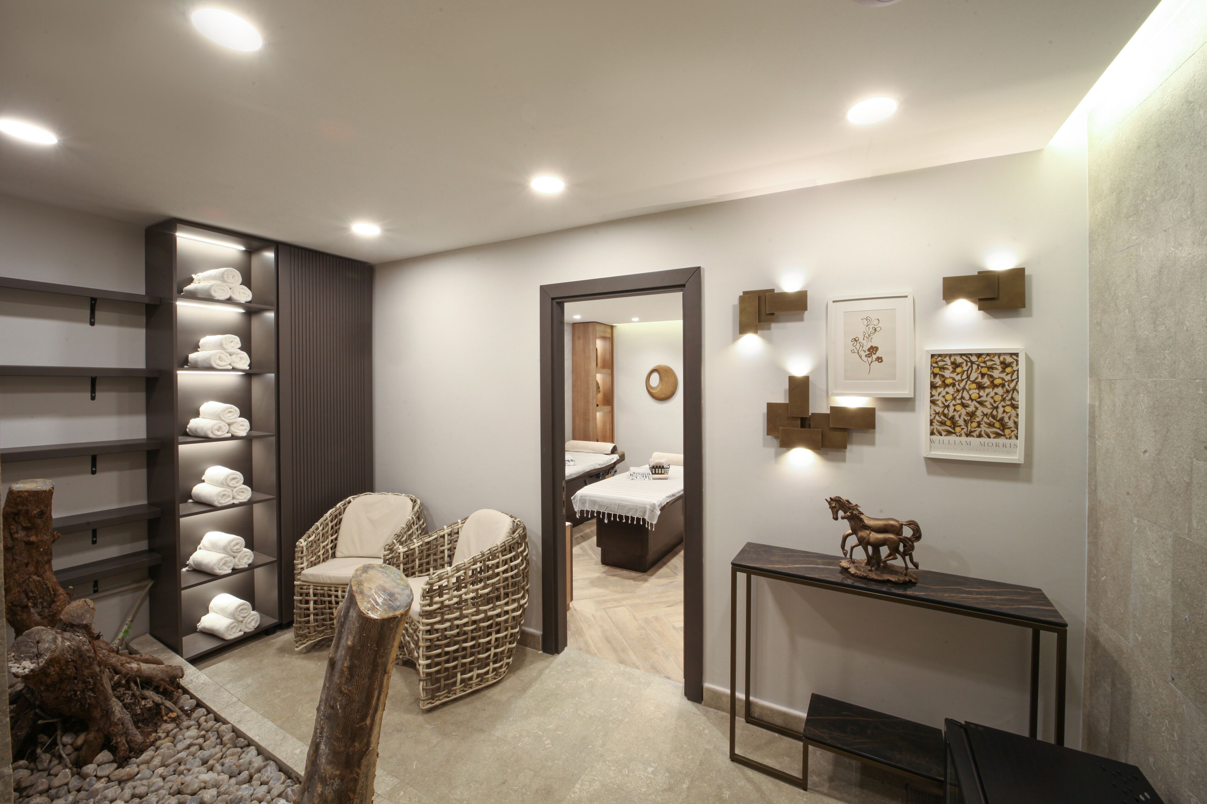 A modern bathroom with a large mirror, towel racks, and a wooden sculpture on a console table.