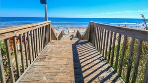 A wooden boardwalk leading to a beach with a 'BONITO' sign. - 🏖️Anchored Inn - updated 4BR/3BA Oceanside home w/Private Pool 🏖️ (Corolla)