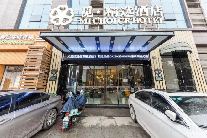 The exterior of the Michoac hotel with a clear entrance, a covered waiting area, and a visible car parking area.