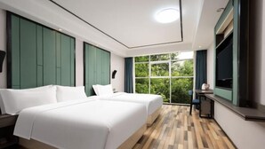 A hotel room with two beds, a large window, and a view of greenery. - Mi Boutique Chain Hotel Xiantao (Xiantao)