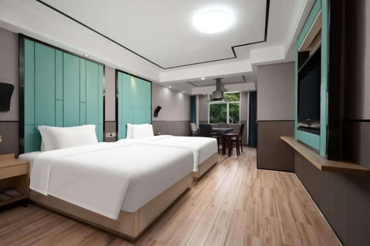 Habitación de hotel moderna con una cama grande, un escritorio y vistas al exterior.