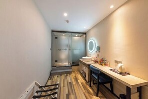 Une salle de bain moderne avec une douche à parois de verre, un meuble-lavabo avec un miroir et un plancher en bois.