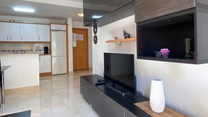 A modern kitchen with white cabinets and a built-in refrigerator.