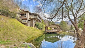 Una cabaña junto al lago, con terraza de madera y un pequeño muelle.