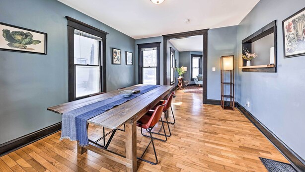A spacious room with a long wooden table, red chairs, and a blue runner. - Newly Renovated Home Close to Dtwn Lawrence! (Lawrence)