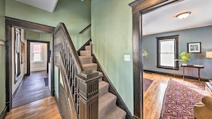 A staircase with wooden railings leading to a room with a large window and a plant. - Newly Renovated Home Close to Dtwn Lawrence! (Lawrence)