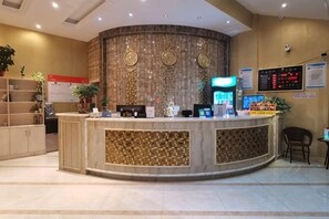 A reception desk with a marble counter, a digital display, and a wall-mounted information board. - jinmingHOTEL (Shangrao)