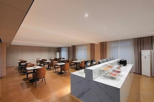 Un comedor de hotel con mostrador de mármol, varias mesas y sillas.