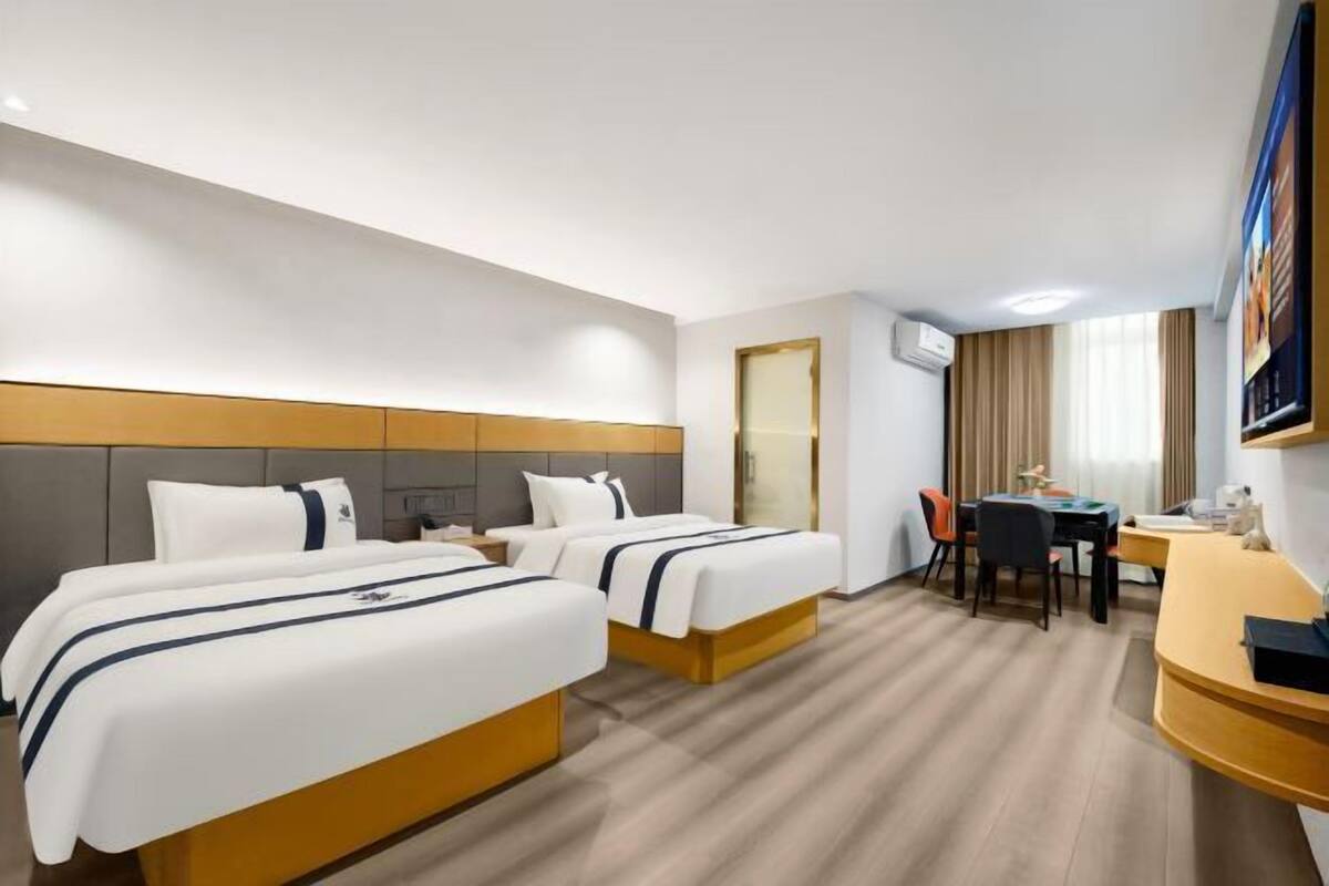 Una habitación de hotel con dos camas, un escritorio y una silla.