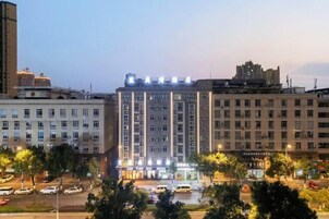Un hotel de varios pisos con un atrio central, rodeado por otros edificios.