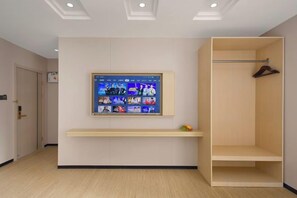 A room with a mounted television, a wooden bench, and a walk-in closet with a hanging rod. - Lingzhi Hotel (Guangzhou)