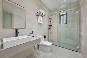 A modern bathroom with a large mirror, a white sink, a toilet, and a glass-enclosed shower. - Lingzhi Hotel (Guangzhou)