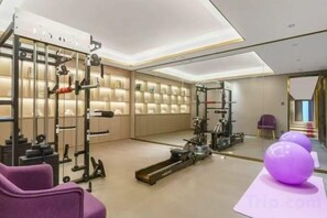 A gym with exercise equipment, a mirrored wall, and a purple exercise ball. - Lingzhi Hotel (Guangzhou)