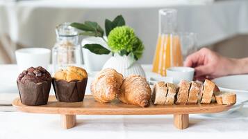A wooden board with pastries and bread slices.