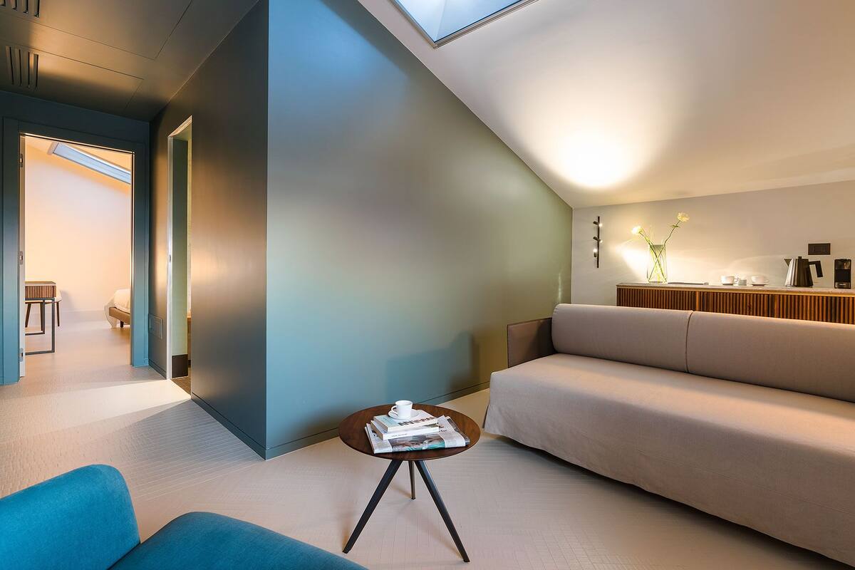Un salon moderne doté d’un plafond en pente, d’un canapé, d’une table basse et d’un coin repas avec une table et des chaises.