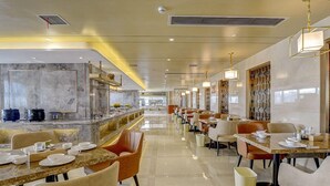 A modern dining area with marble countertops, multiple tables, and chairs. - Vienna Hotel (Nanchang County Chengbi Lake) (Nanchang)