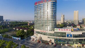 A modern hotel with a curved facade, multiple floors, and a prominent signage. - Vienna Hotel (Nanchang County Chengbi Lake) (Nanchang)
