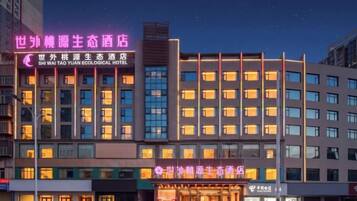 A hotel with multiple floors, a prominent entrance, and illuminated signage.