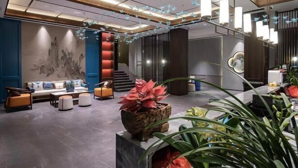A modern lobby with a sofa set, a coffee table, and a decorative plant centerpiece. - Shiwai Taoyuan Eco Hotel (Huaihua)