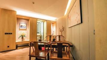 A dining area with wooden furniture, a vase with flowers, and a painting on the wall.