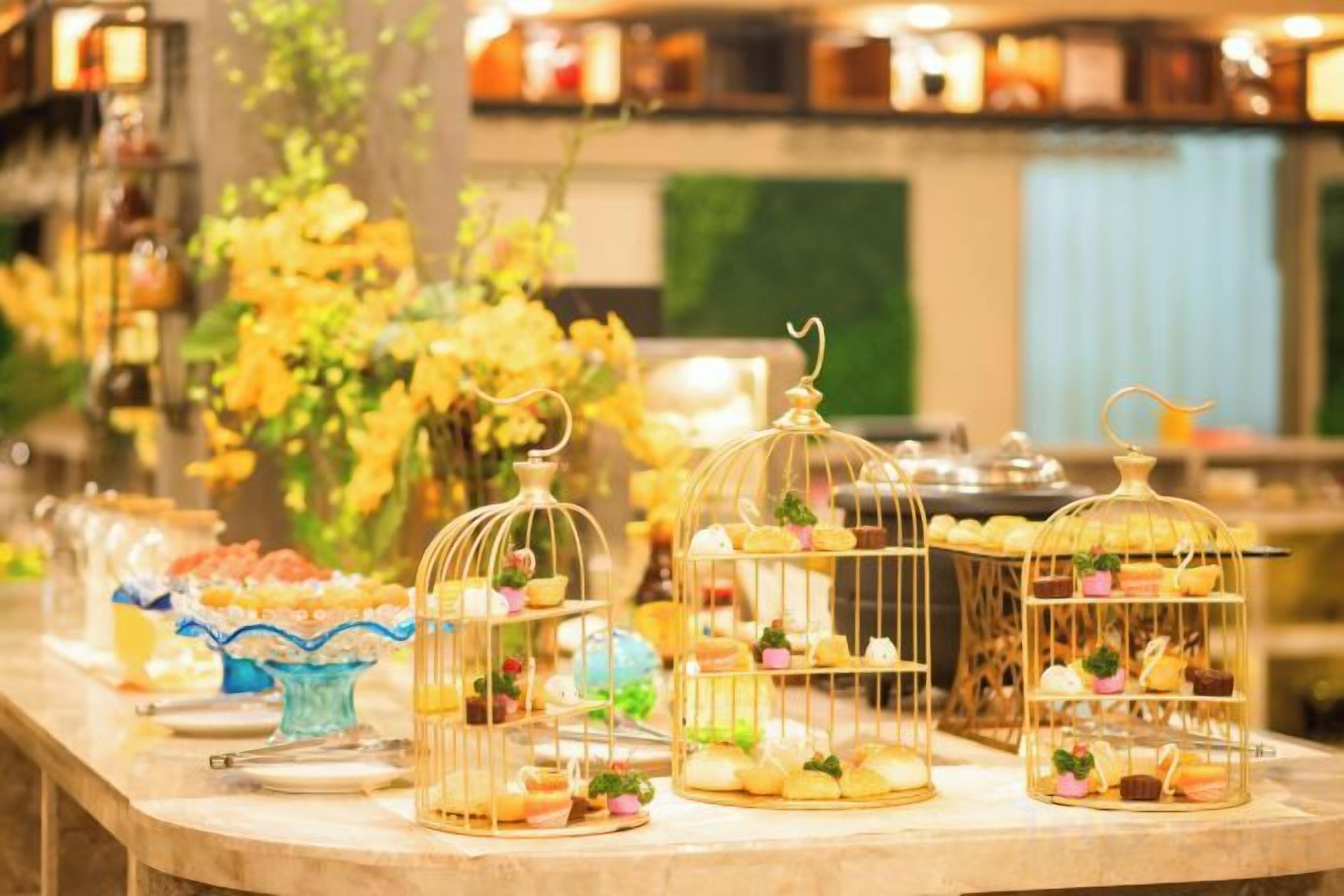A buffet table with various food items displayed in glass containers and on plates.