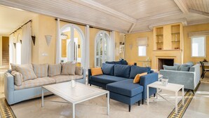 A spacious living room with a high ceiling, a fireplace, and a large window. - Villa Rosa with Pool, Garden and Wi-Fi (Benalup-Casas Viejas)