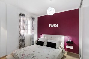 A bedroom with a bed, a nightstand, a wall-mounted shelf, and a decorative light fixture. - Apartment Apartamento Porís close to the Beach with Shared Pool & Wi-Fi (Arico)