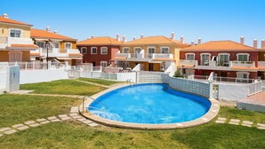 A residential area with a swimming pool surrounded by houses with red-tiled roofs. - Apartment Apartamento Porís close to the Beach with Shared Pool & Wi-Fi (Arico)