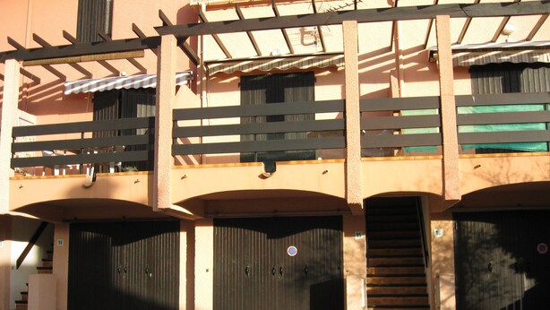 A building with multiple garage doors, a staircase, and a covered walkway. - T2 mezzanine near beach and shops (Saint-Cyprien)