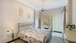 Une chambre à coucher comprenant un lit, une table de chevet, une lampe, une commode et un miroir.