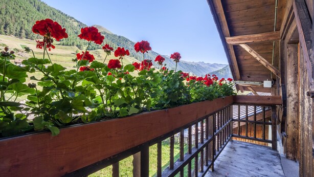 A wooden balcony with a railing overlooking a mountainous landscape. - Apartment "Rieglhof Hennennest" with Mountain View, Garden & Wi-Fi (Graun im Vinschgau)