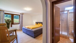 A bedroom with a bed, a table, and a chair. - Apartment "Rieglhof Hennennest" with Mountain View, Garden & Wi-Fi (Graun im Vinschgau)