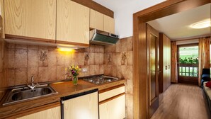 A kitchen with wooden cabinets, a stainless steel sink, and a gas stove.