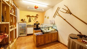 A rustic interior with wooden cabinets, a glass display case, and a ladder against the wall.