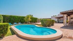 A swimming pool with lounge chairs, surrounded by greenery and a patio area. - Finca Villa Tranquila en Pollensa with Mountain View, Pool, Garden & Wi-Fi (pollensa)