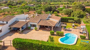 A villa with a swimming pool, outdoor seating, and a view of the surrounding countryside. - Finca Villa Tranquila en Pollensa with Mountain View, Pool, Garden & Wi-Fi (pollensa)