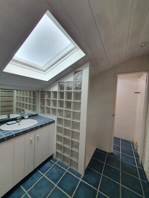 A bathroom with a skylight, a sink, and a tiled floor. - Charming Penty 250m from the beach - 10min from Pointe du Raz (Primelin)