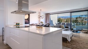 A modern kitchen with a large island, dining area with a view, and a cozy seating area with a view.