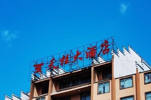 A building with a sign in red characters on the roof.